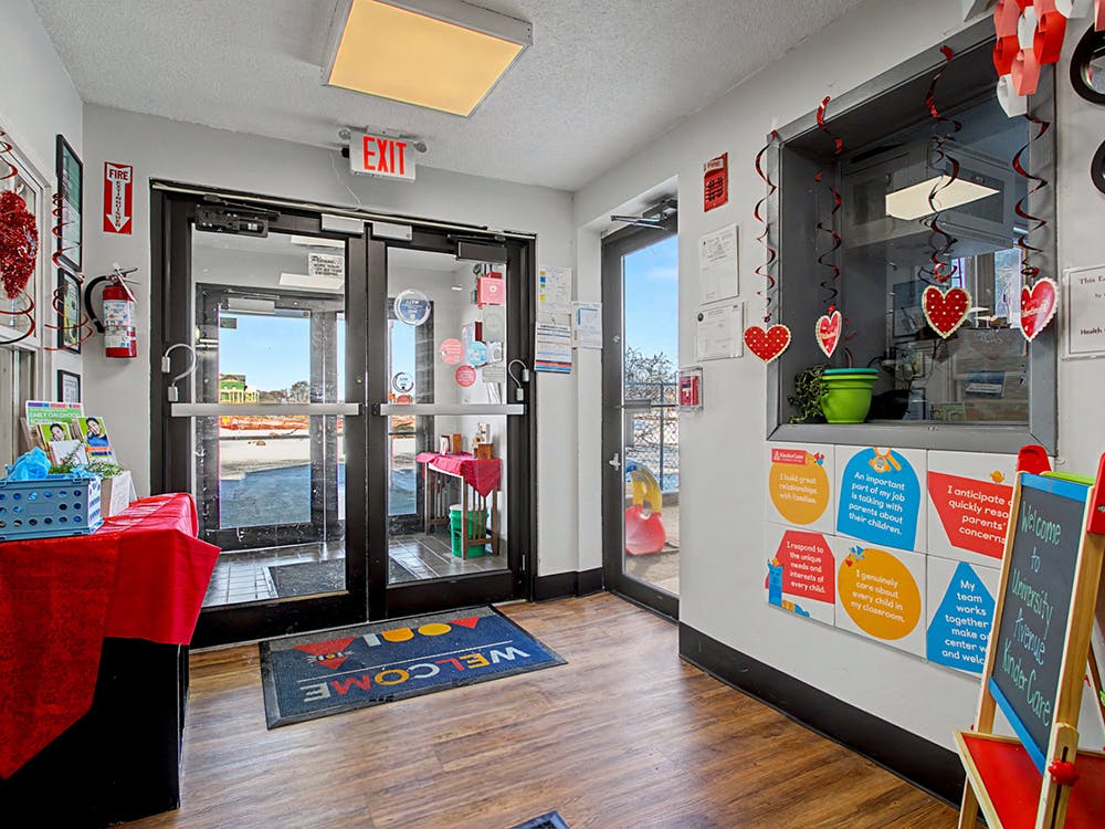 Lobby of a building with glass doors, welcome mat, and an 'EXIT' sign