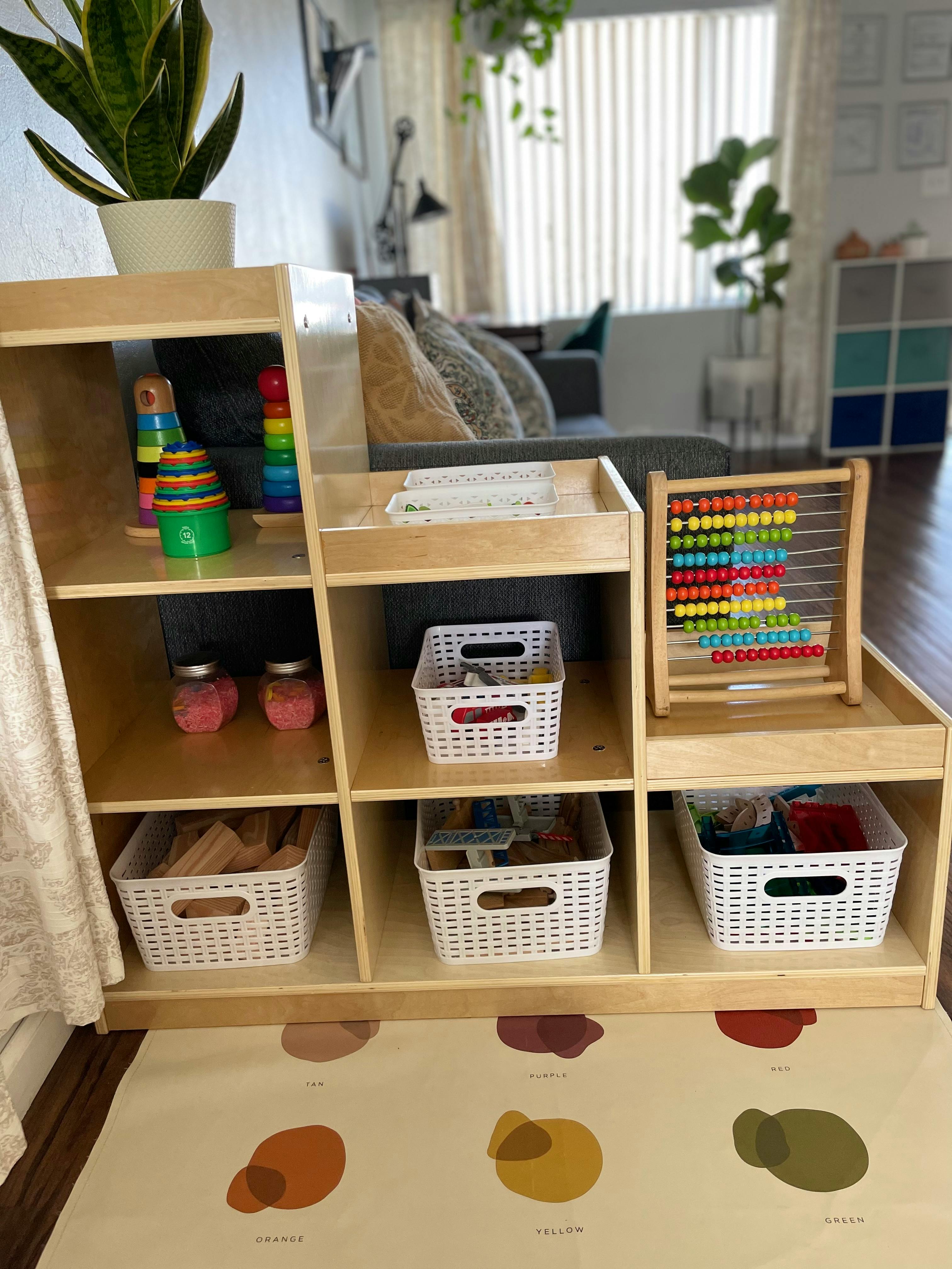 Wooden shelving unit with toys, baskets, and an abacus