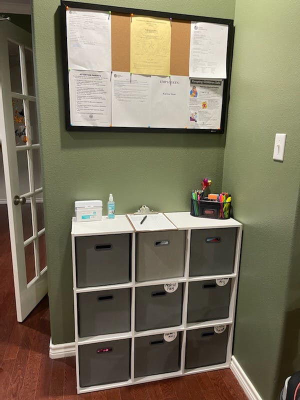 Bulletin board with papers above a storage unit with cubbies