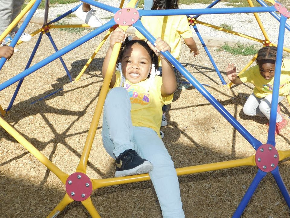 Child climbing on a geometric dome climber