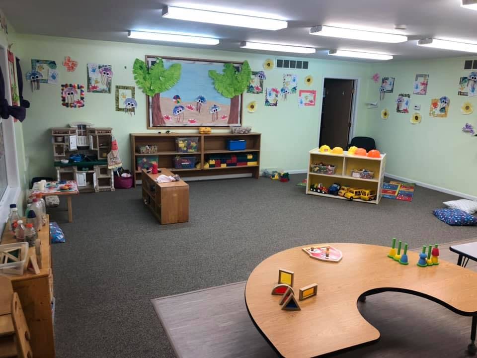 Classroom with shelves of toys and a U-shaped table