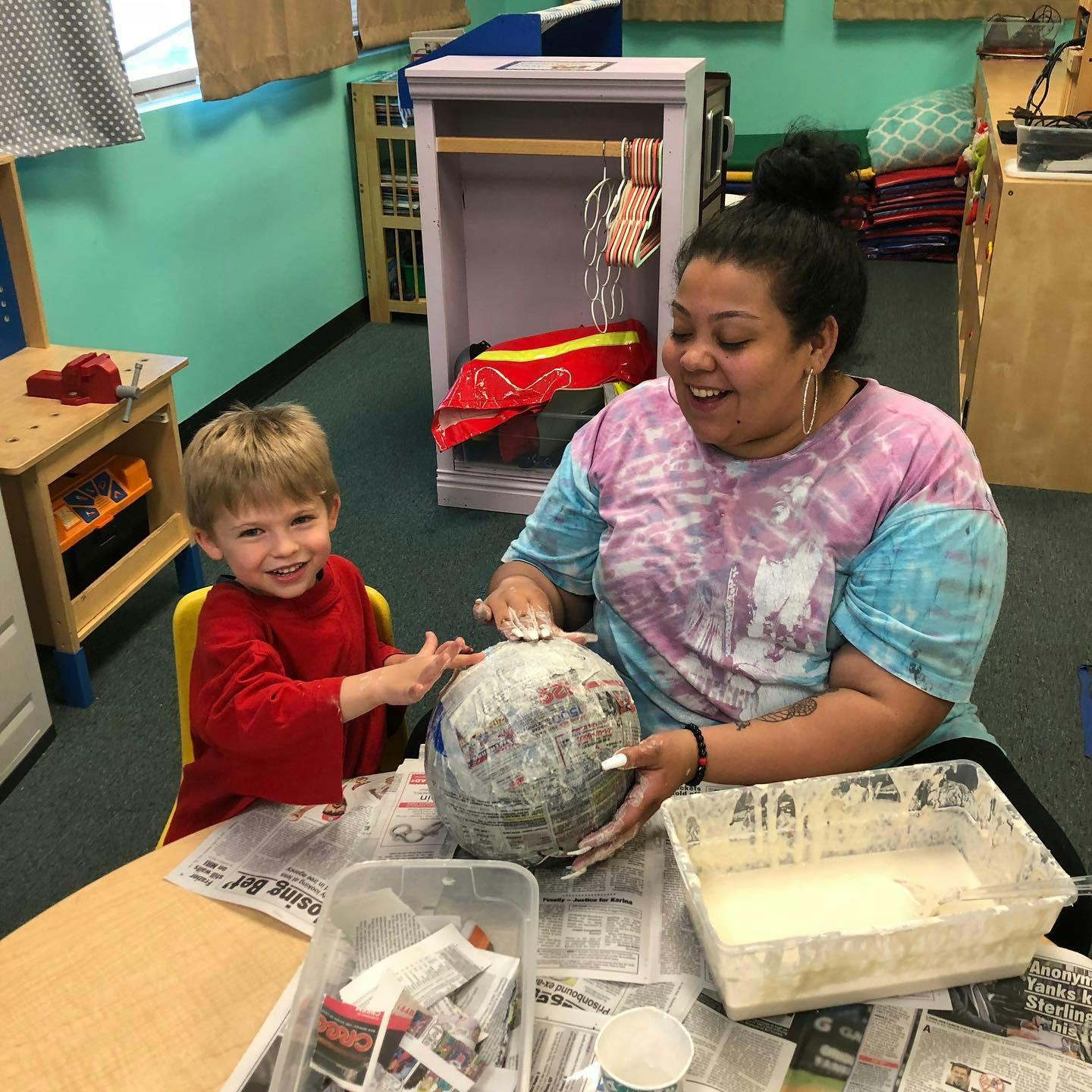 Person and child making paper mache globe