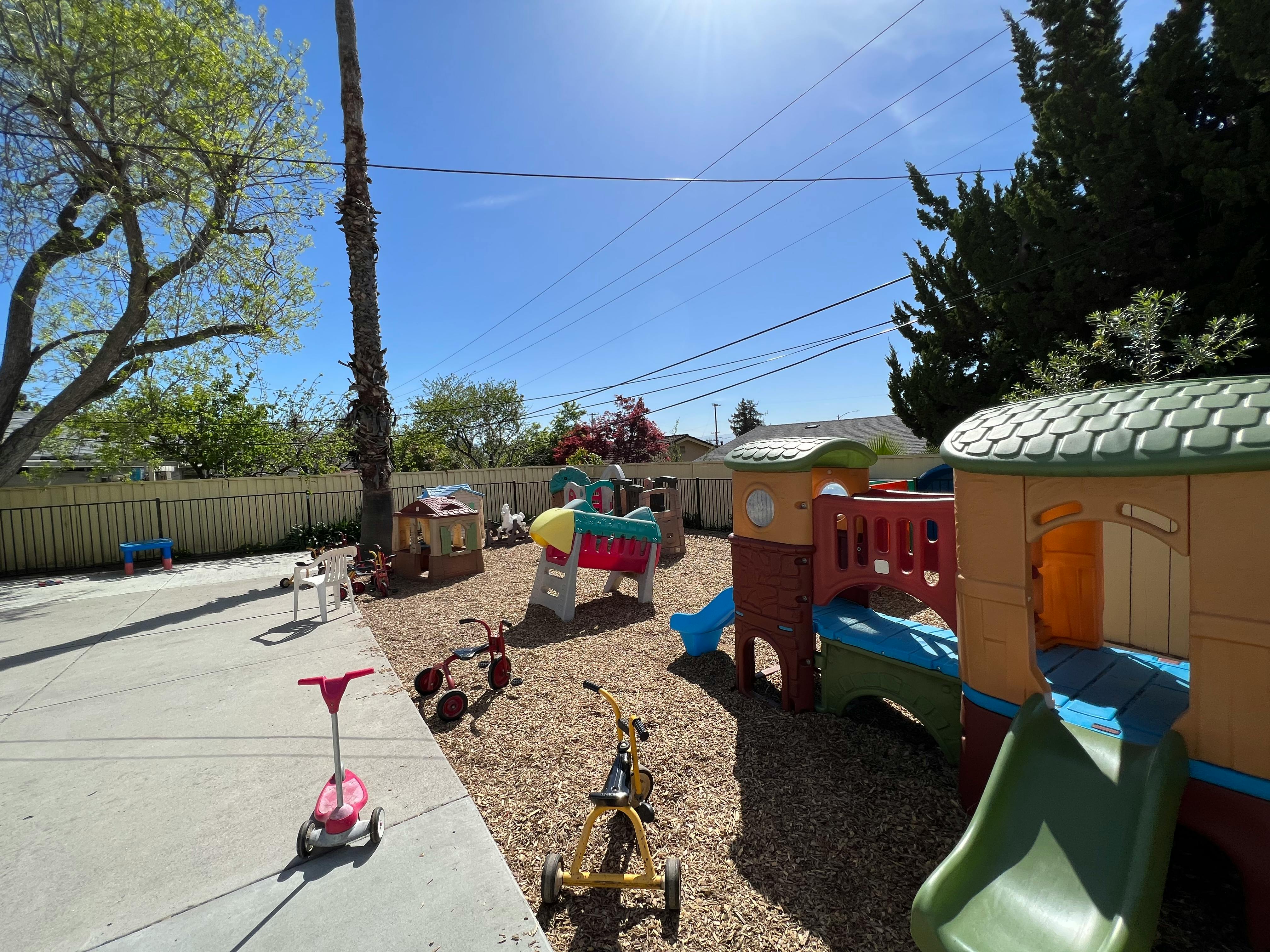 Outdoor playground with slides, playhouses, and tricycles