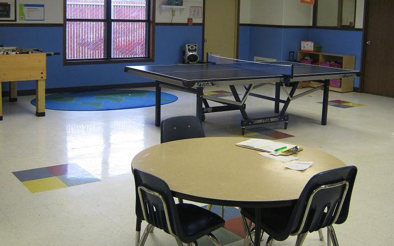 Playroom with a foosball table, a ping pong table, and a round table with chairs