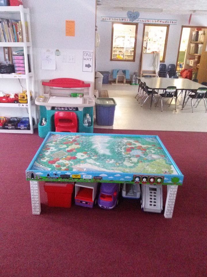 Playroom with a toy table, toy kitchen, and small tables with chairs