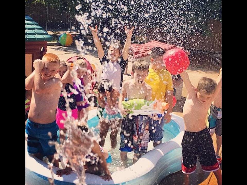 Children playing in a pool with water splashing