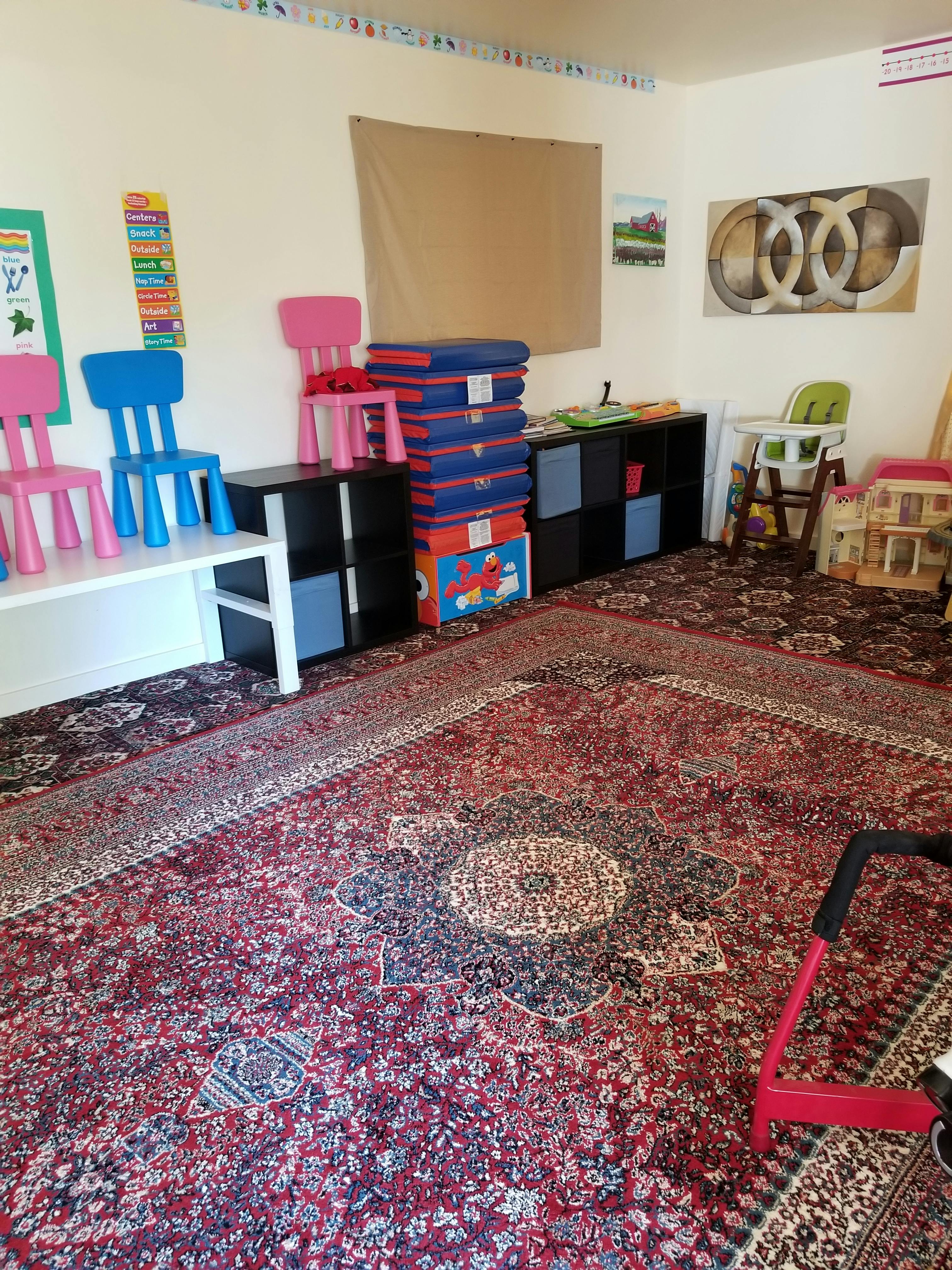 Playroom with small chairs, storage cubes, and a patterned rug