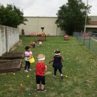 Children playing outdoors in a grassy area