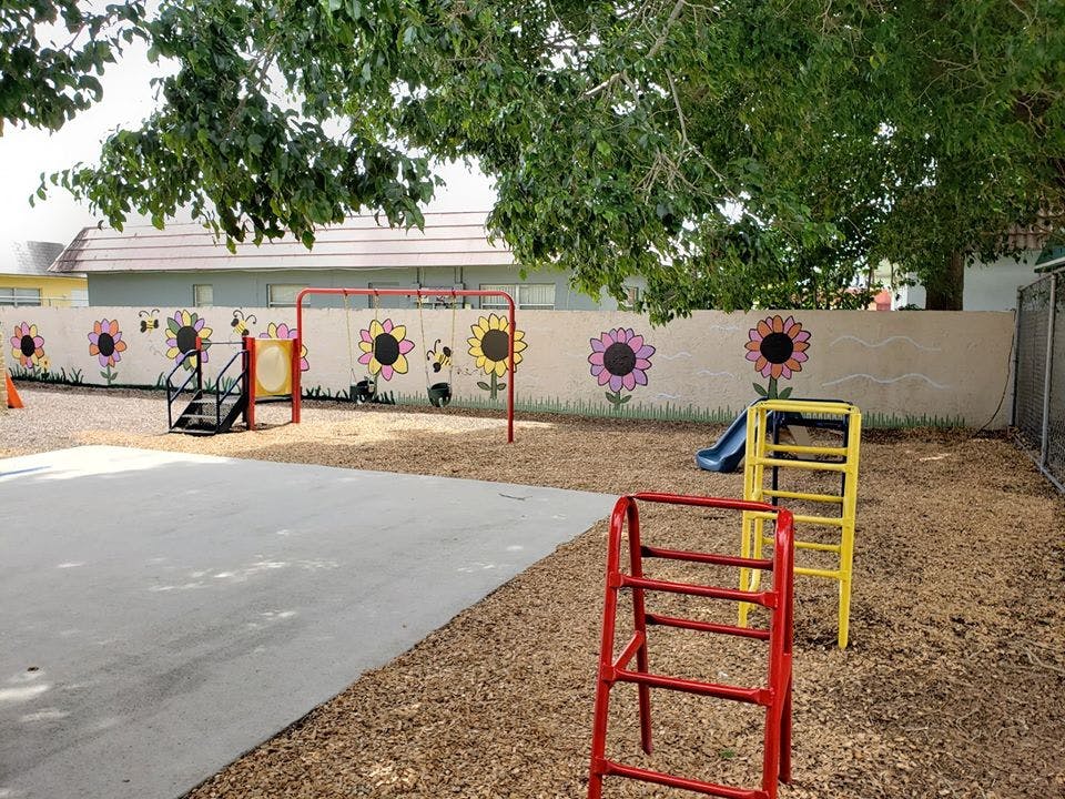 Playground with climbing structures and a wall painted with sunflowers