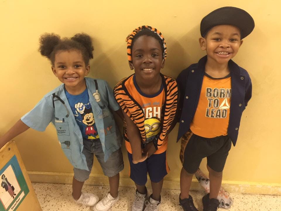 Three children standing and smiling