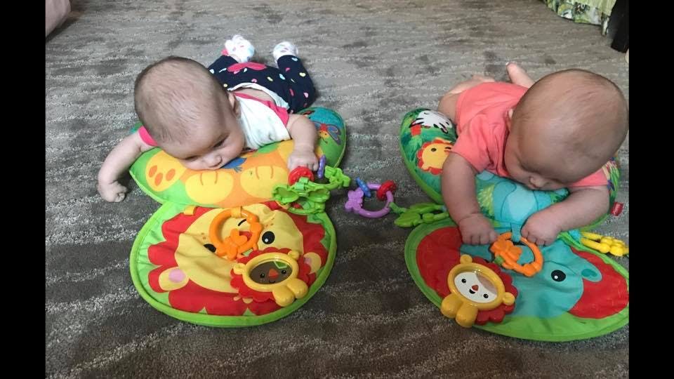 Two babies lying on play mats