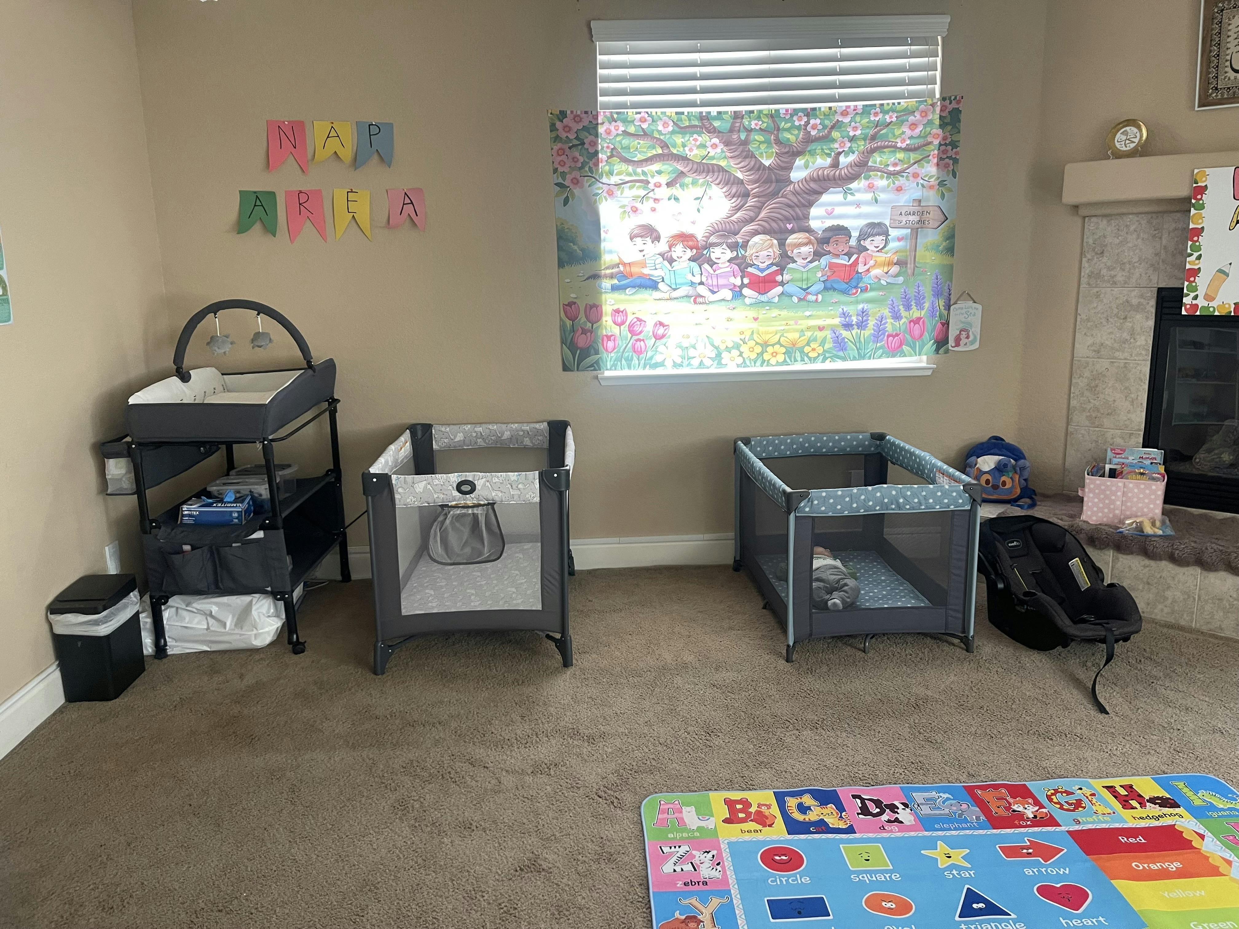 Baby changing station and two playards in a room with a colorful playmat