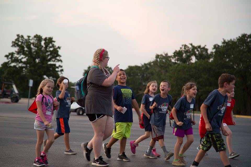 Adult and group of children walking outdoors