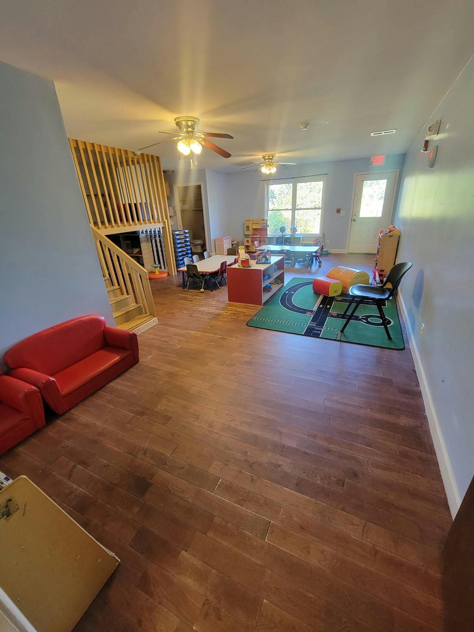 Playroom with toys, small chairs, and rug on hardwood floor