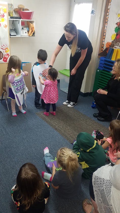 Adult with children dressed in costumes in a classroom
