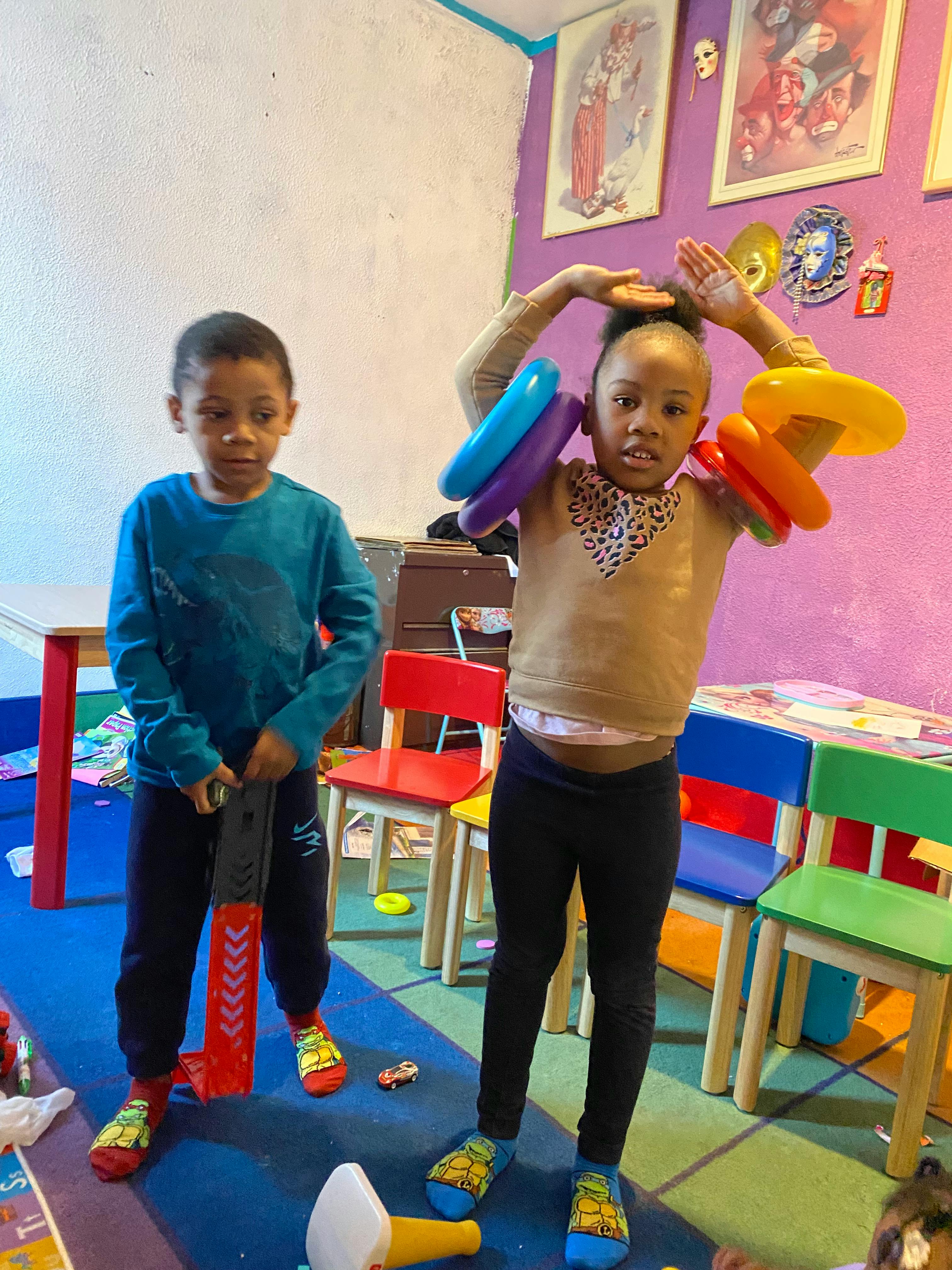 Child holding a toy bat, child with colorful rings on arms