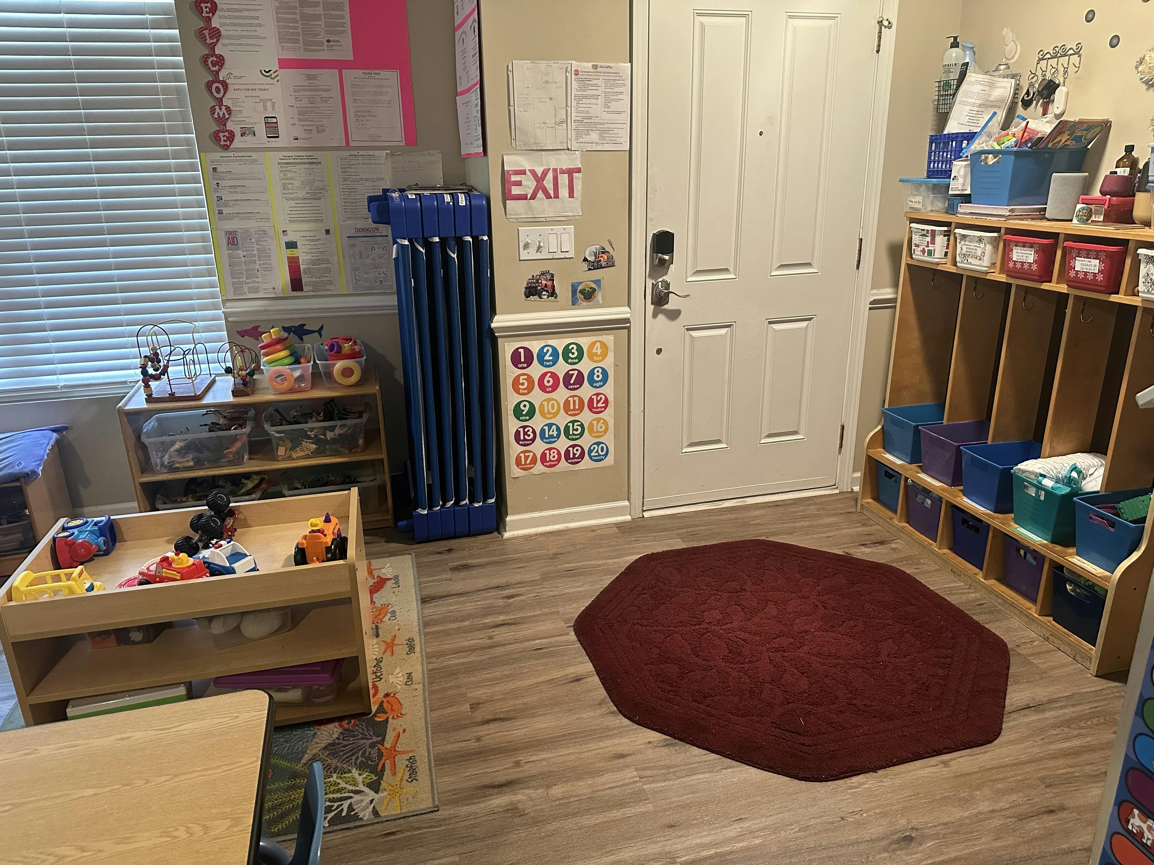 Classroom with cubbies, toys, and an exit sign