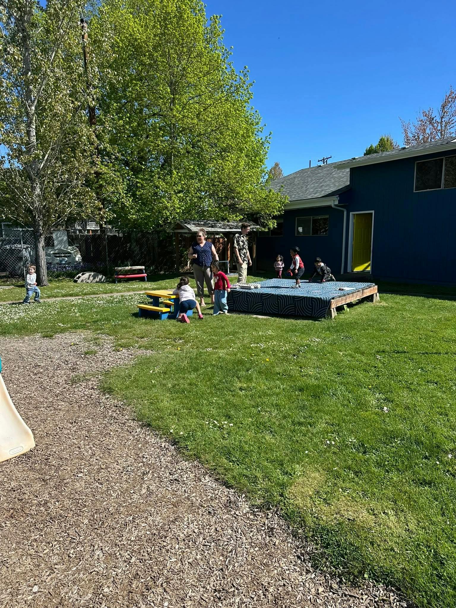 People and children in a grassy outdoor area