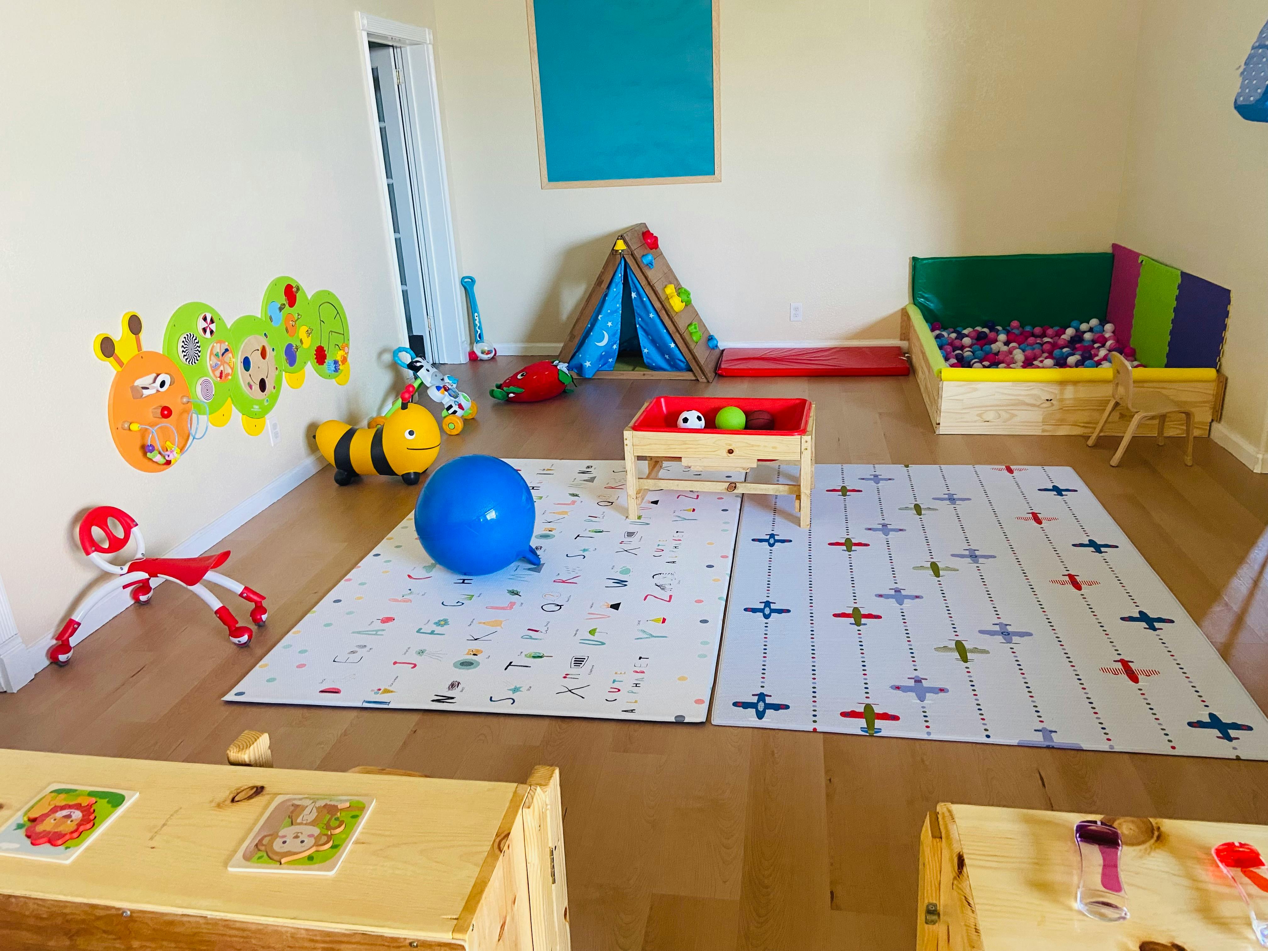 Playroom with a blue ball, play mat, and various toys