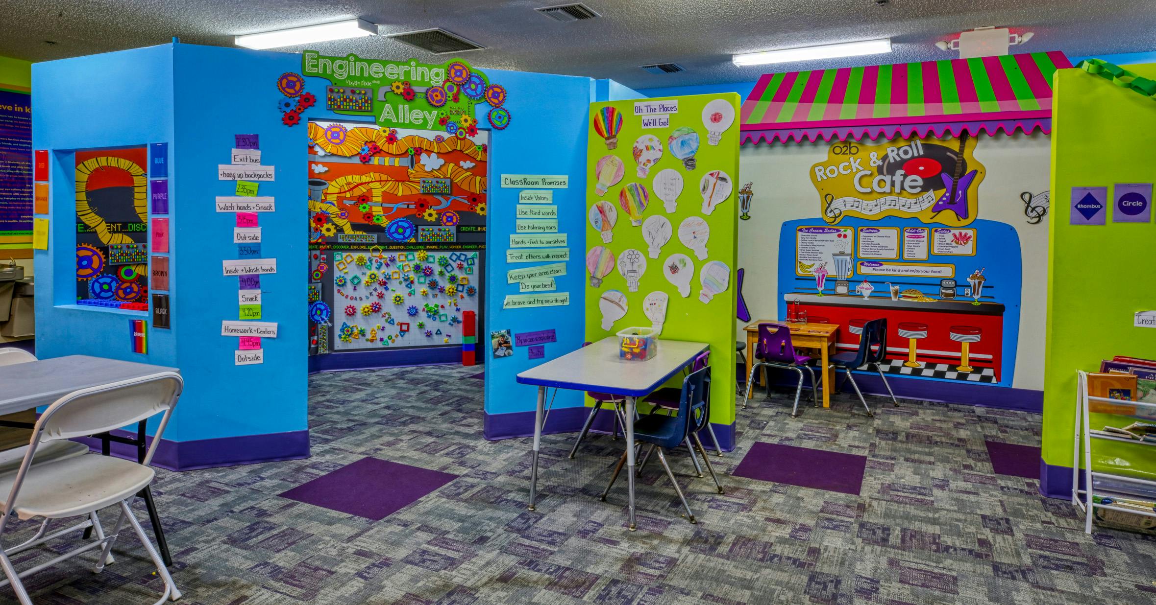 Colorful children's activity room with signs for "Engineering Alley" and "Rock & Roll Cafe"
