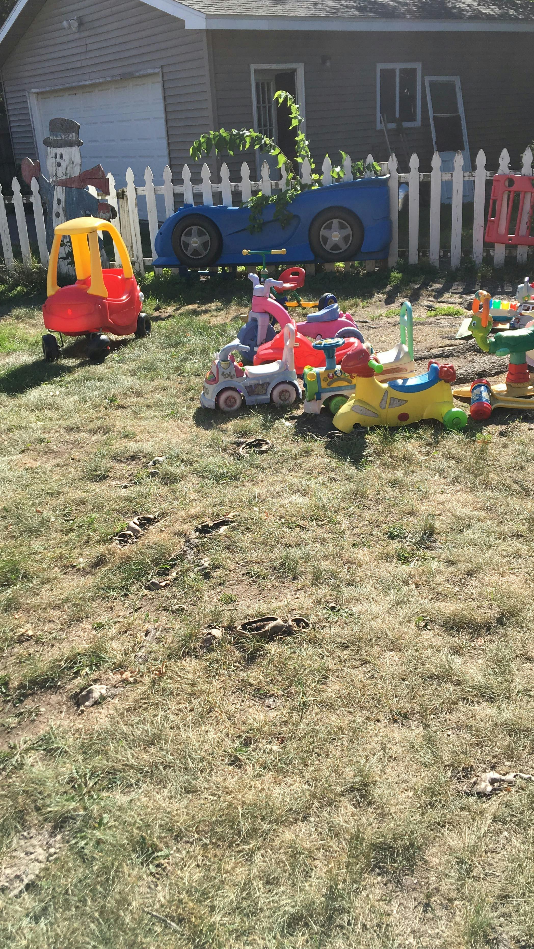 Group of various toy ride-on vehicles on a grassy lawn