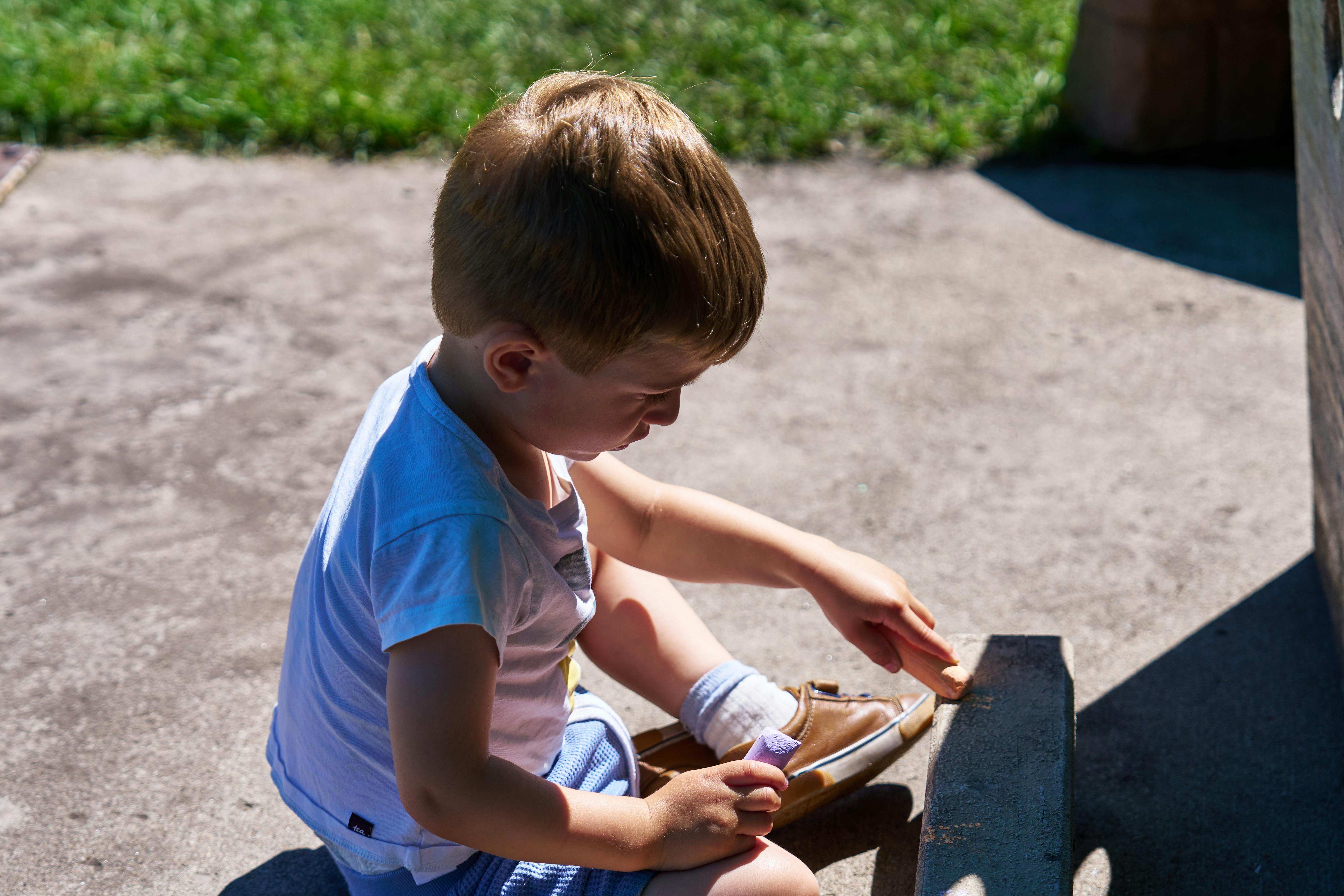 Child kneeling and touching a surface