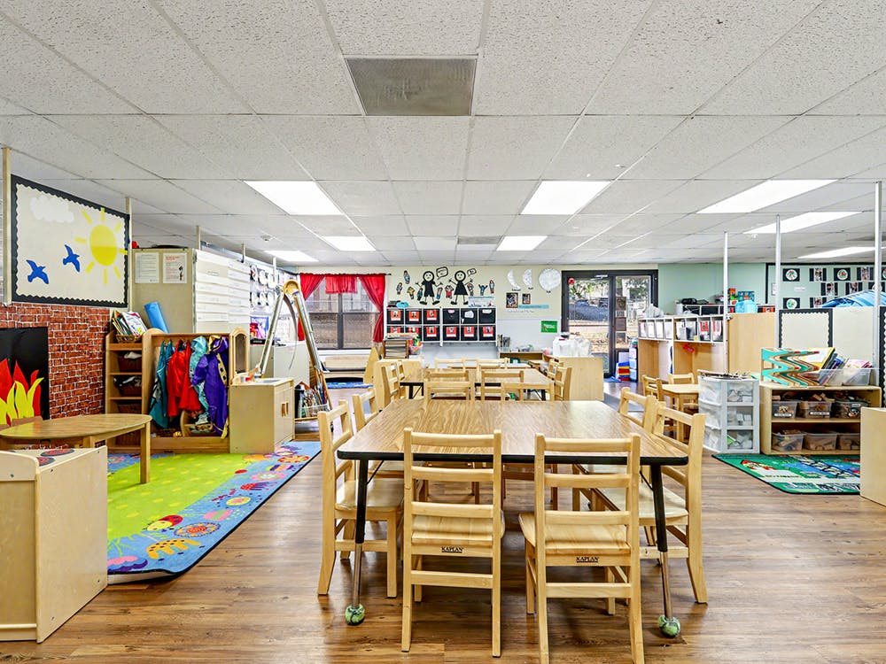 Classroom with small tables, chairs, and colorful decorations