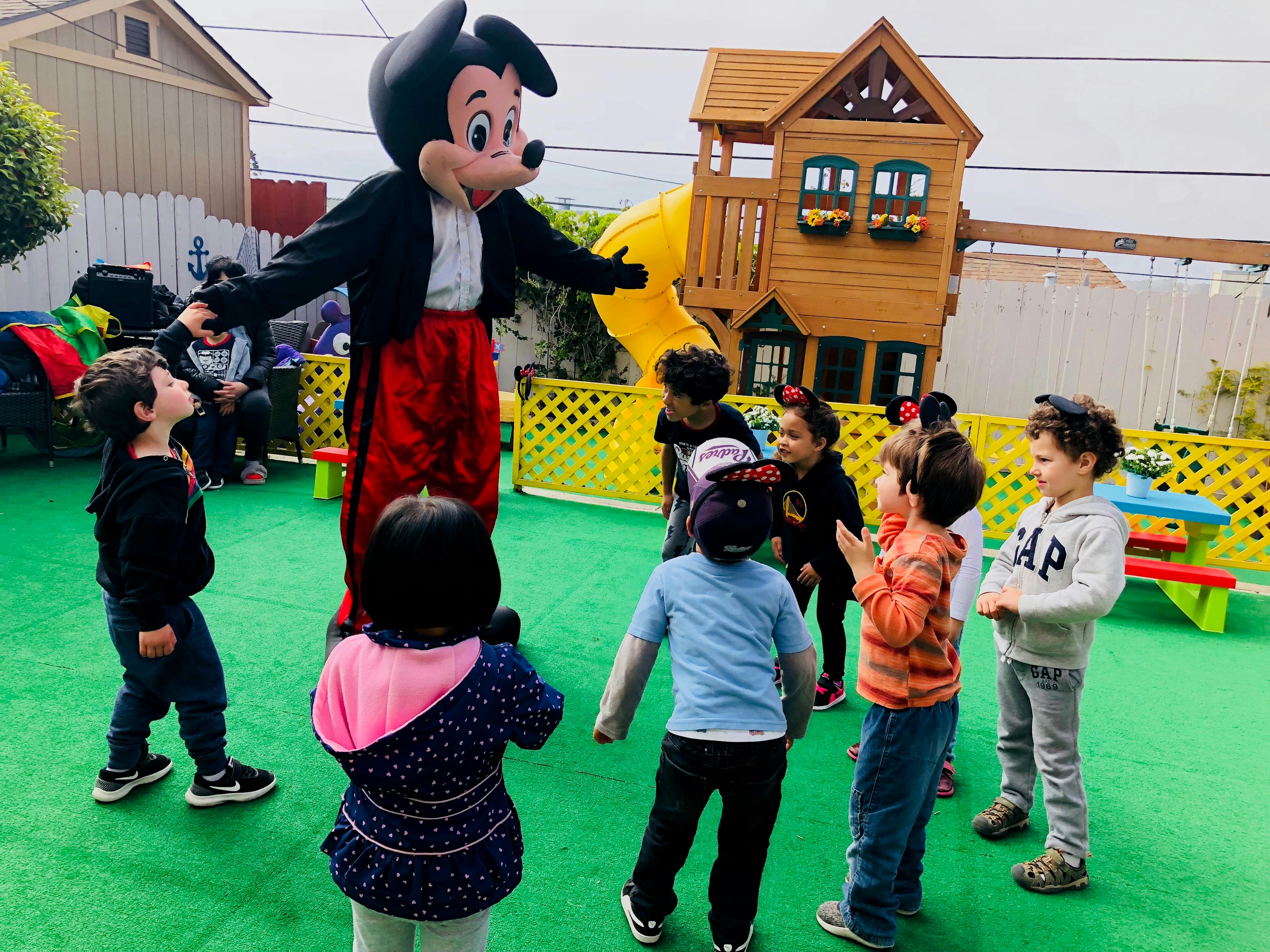 Person in character costume interacting with children on a playground