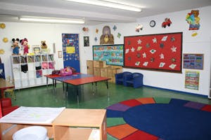 Empty classroom with tables, chairs, and colorful decorations