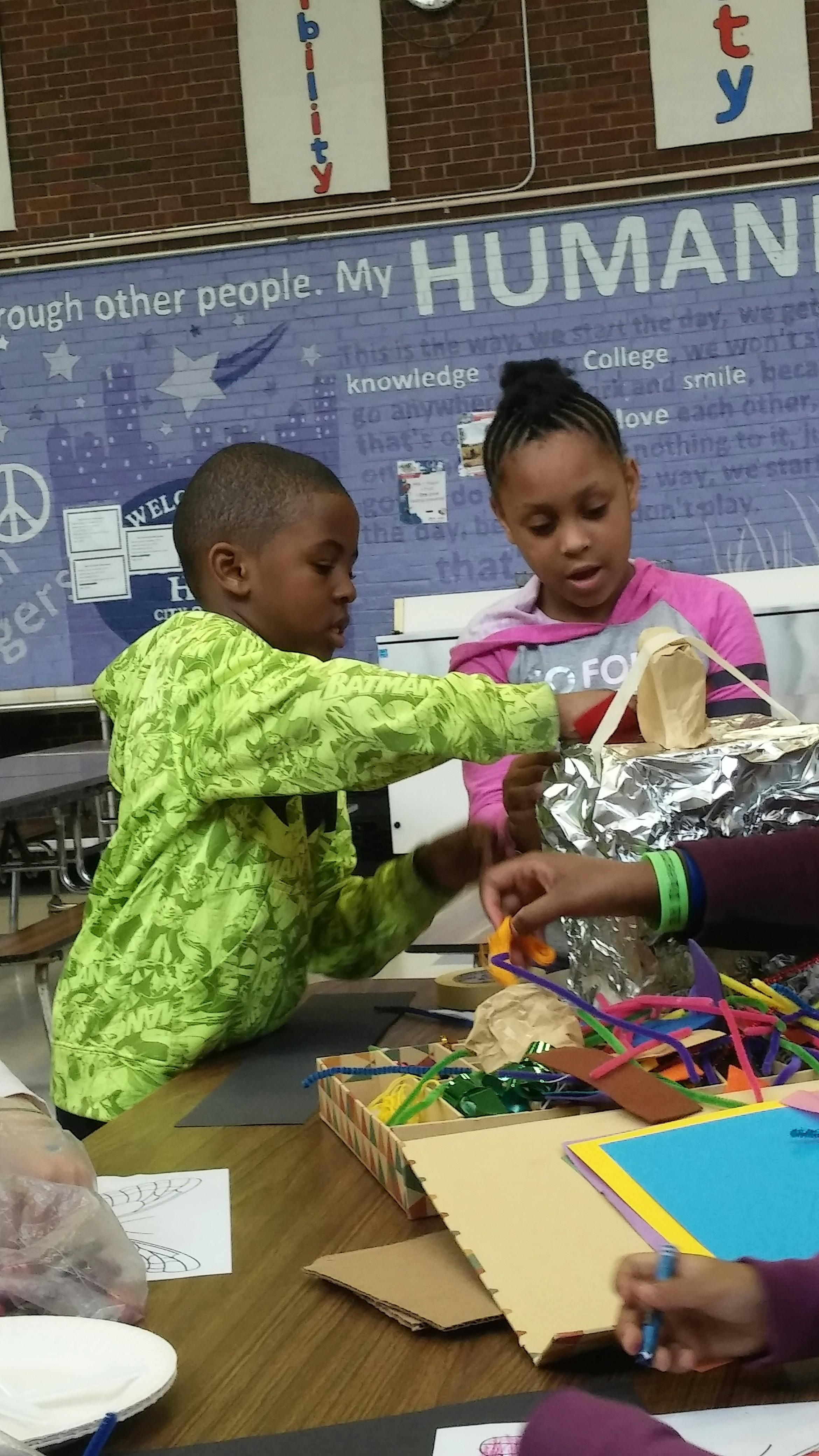 Two children working on a craft project at a table