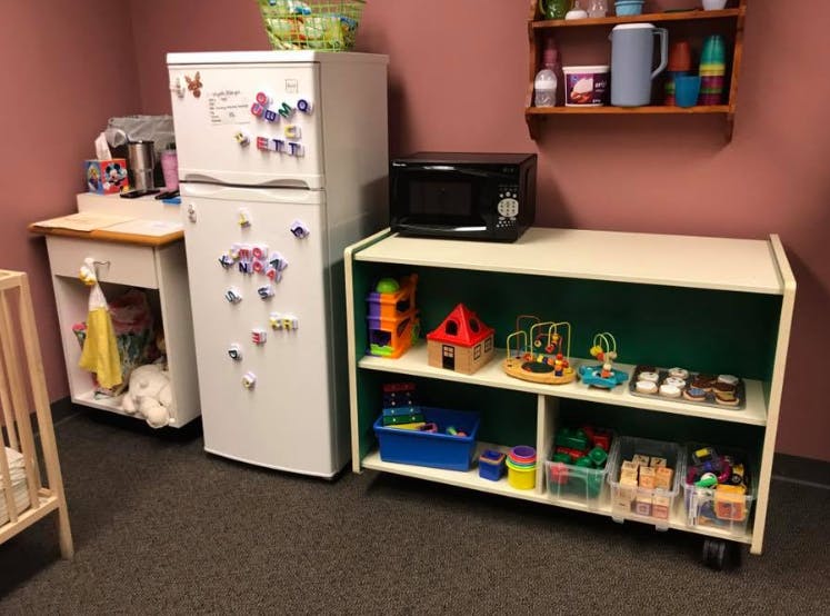 Refrigerator with magnets next to a shelf with toys