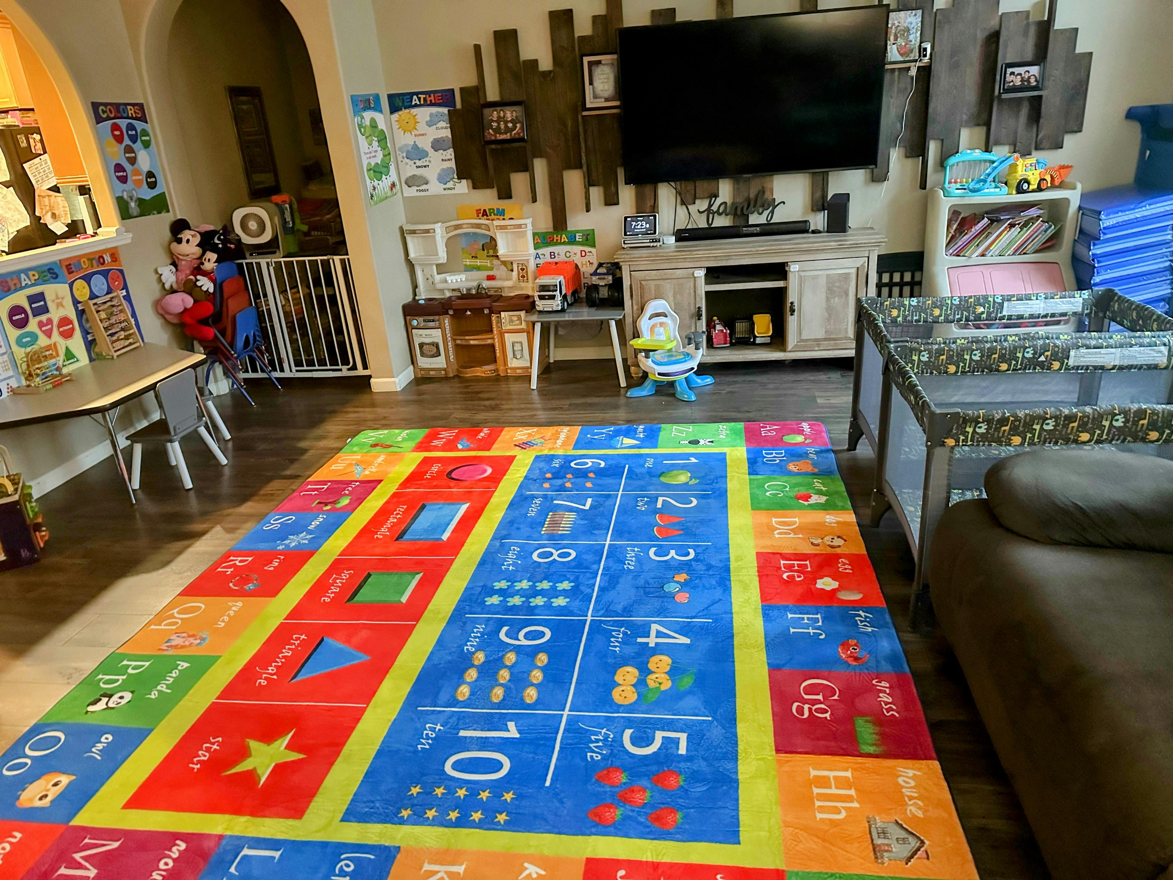 Colorful rug with numbers and letters in a room with children's play items