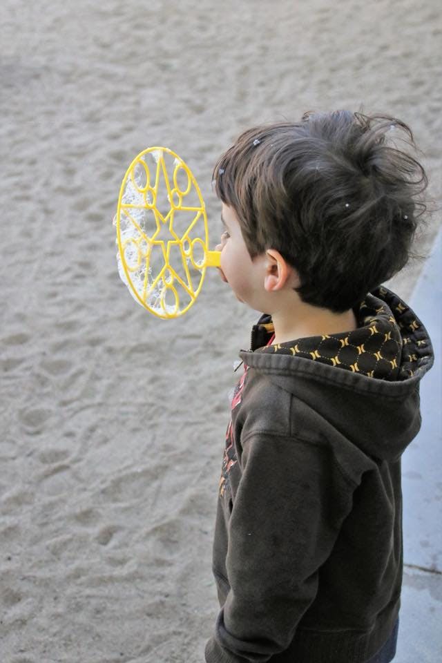 Child blowing bubbles with a bubble wand