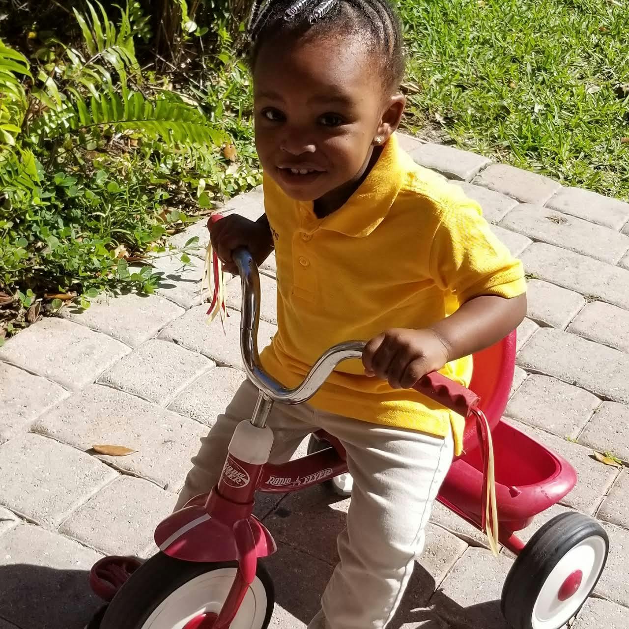 Child on a red tricycle