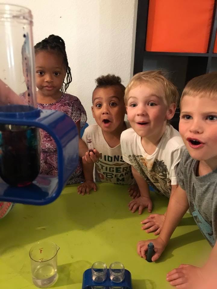 Children watching a science experiment with beakers and test tubes