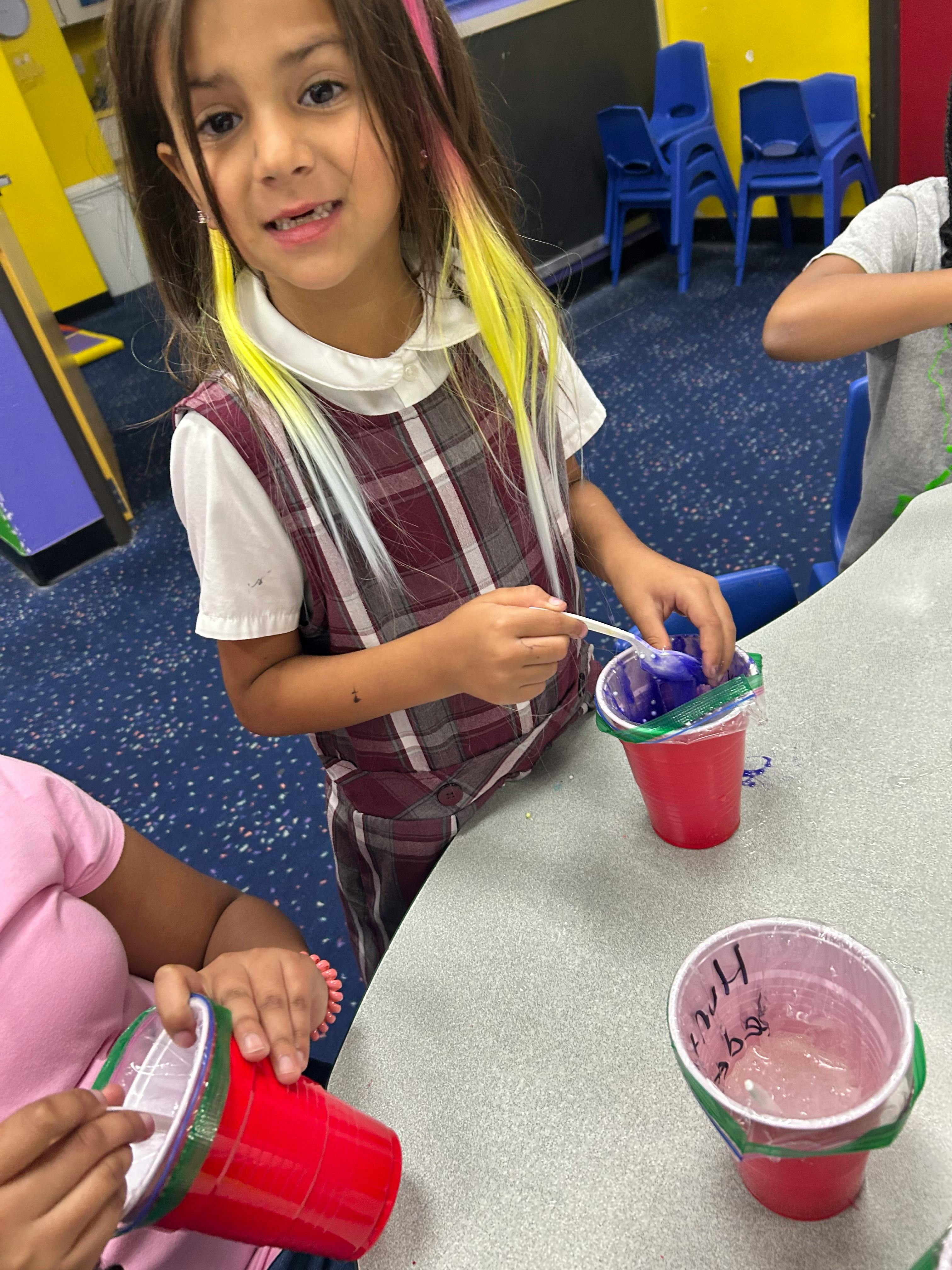 Child mixing something in a red cup