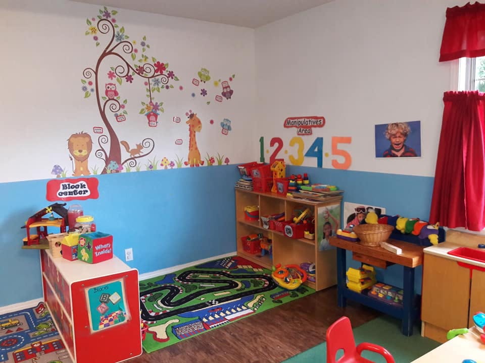 Playroom with colorful wall decals, toys, and a rug with a road design