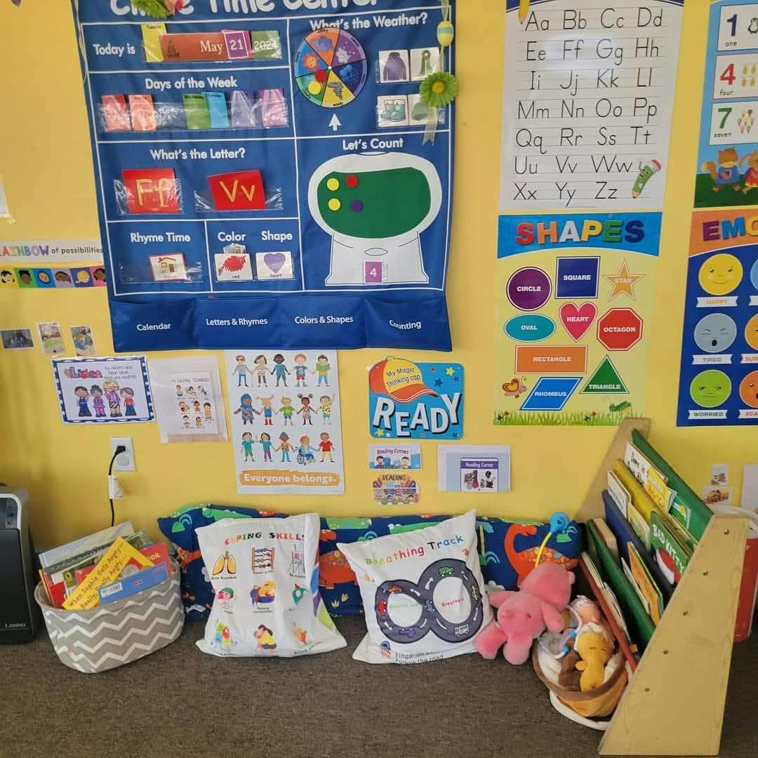 Classroom wall with educational charts, pillows, and books