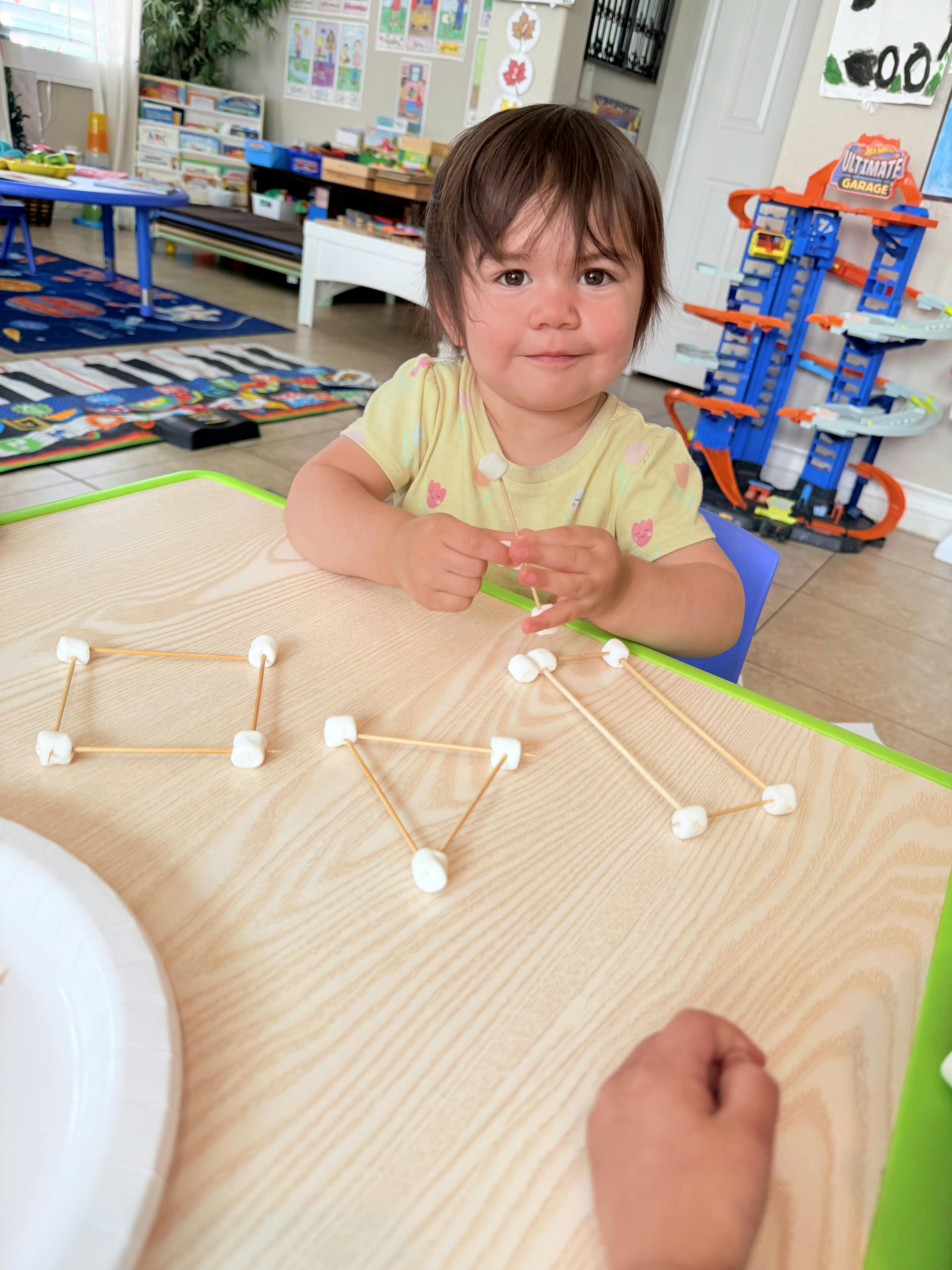 Child making shapes with toothpicks and marshmallows