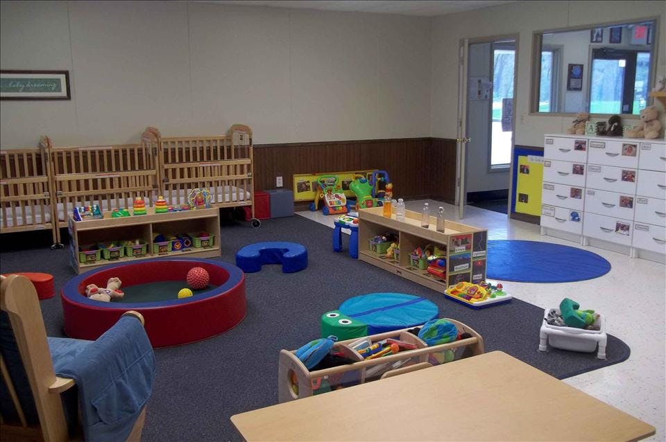 cribs, toys, and furniture in a daycare or nursery room