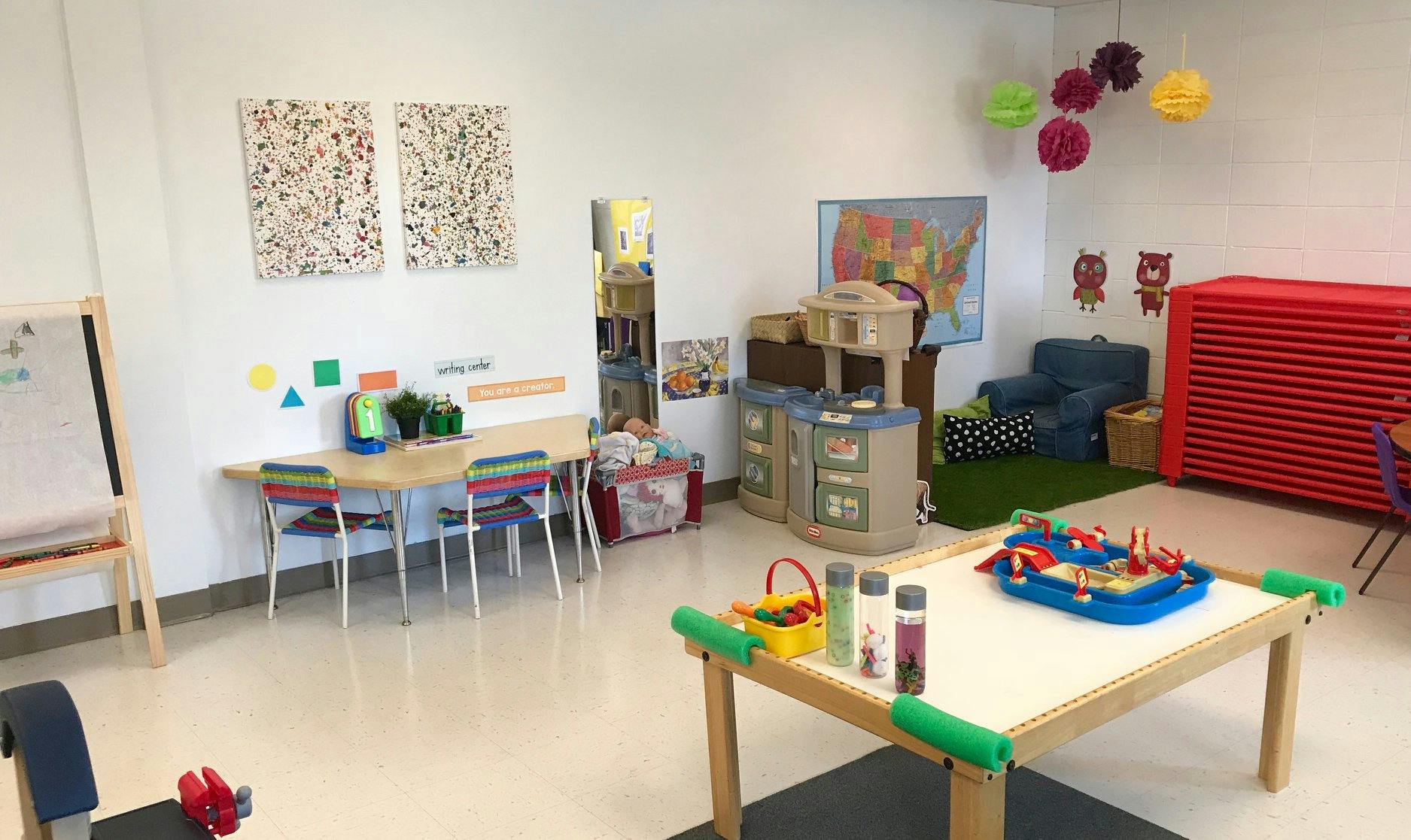 Playroom with small tables, chairs, and play kitchen