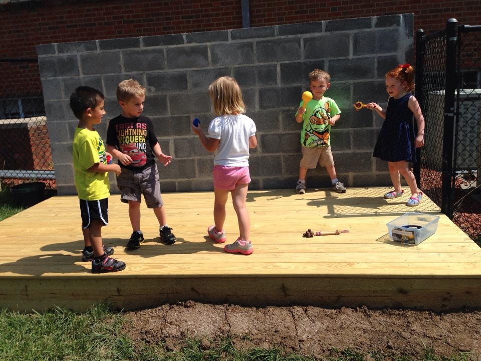 Children playing with toys on a wooden platform