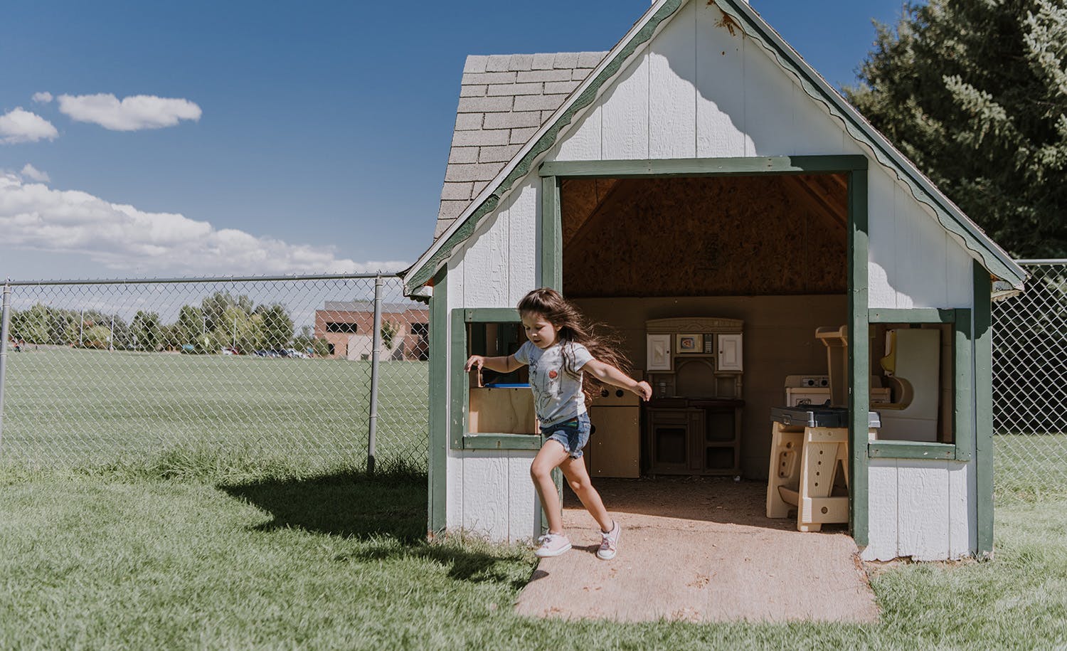 Child running out of a playhouse