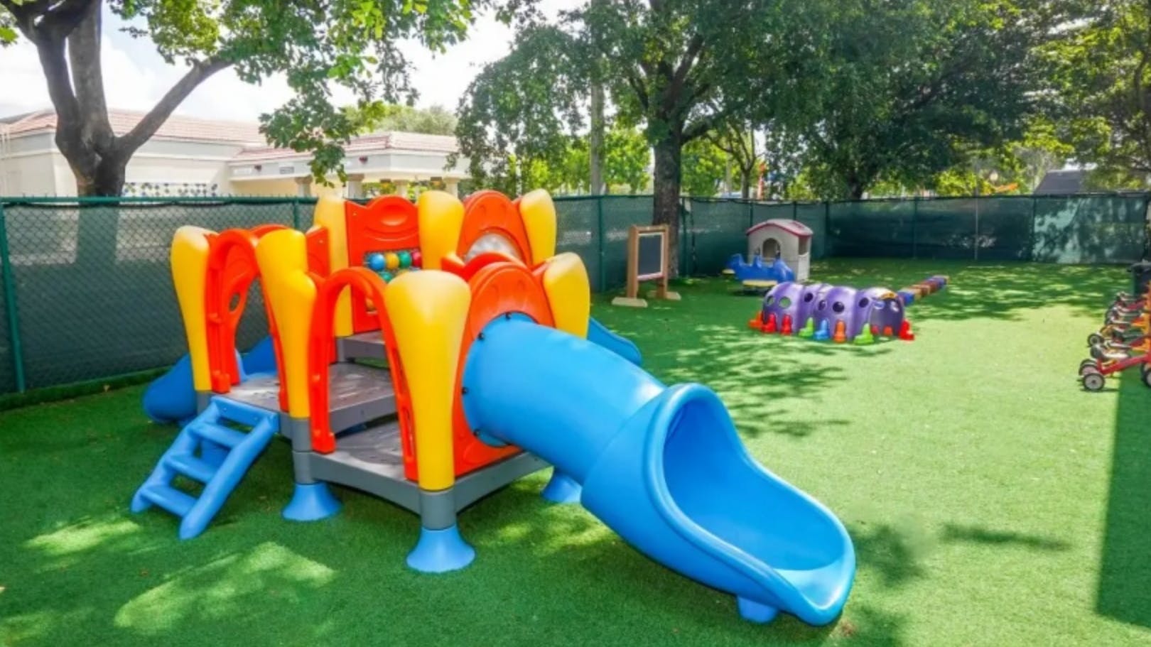 Playground with colorful slide and climbing structure on artificial turf