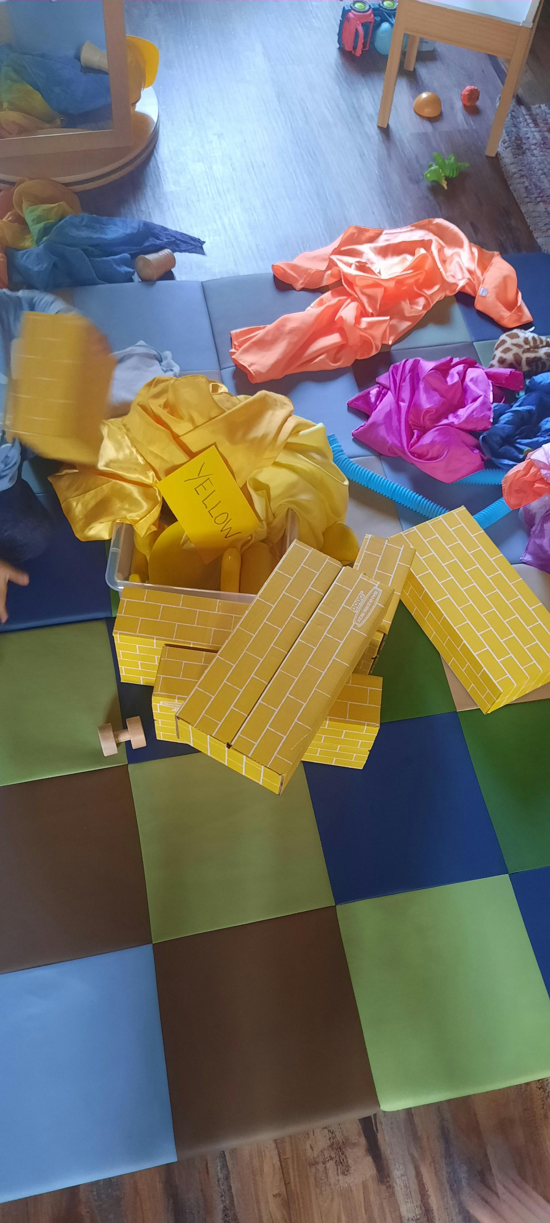 Yellow fabric and yellow brick-patterned boxes on a playmat