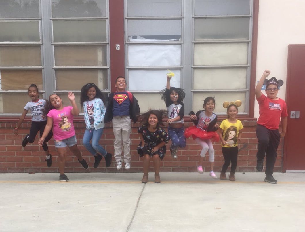 Group of children jumping in front of a building