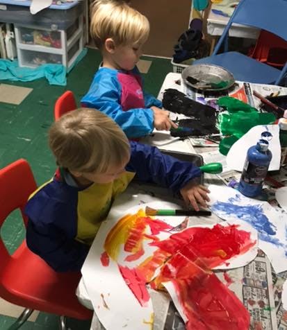 Two children painting at a table