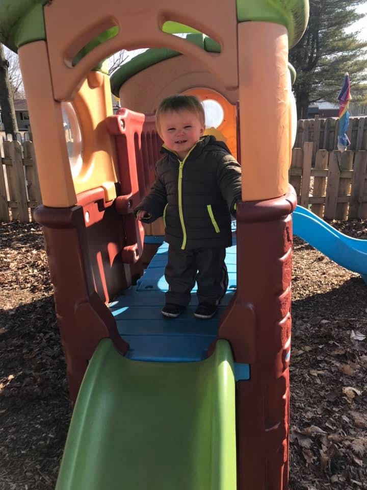 Child standing on a playground slide platform