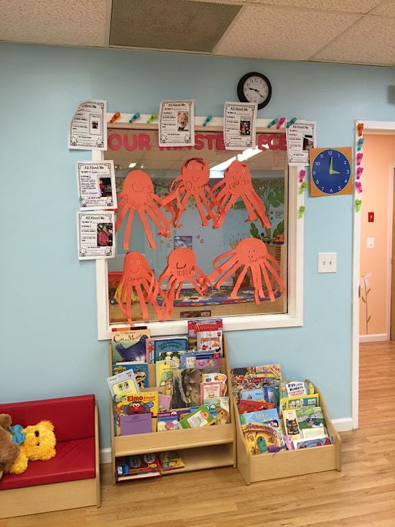 Classroom window with paper octopus decorations and book displays below