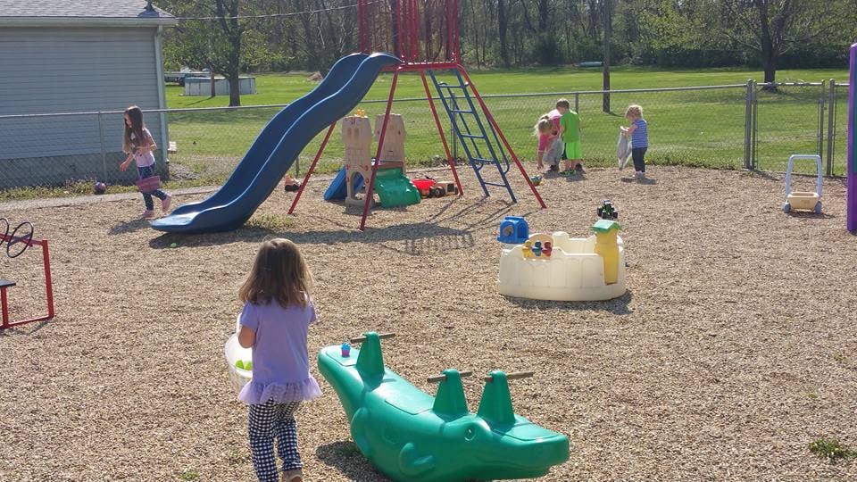 Children playing on a playground with a slide and other equipment